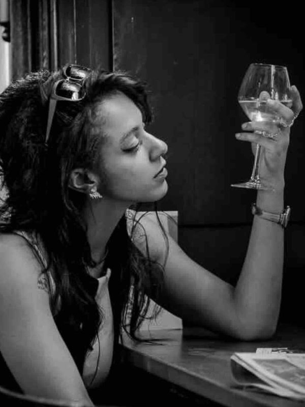 Portrait noir et blanc d'une jeune femme regardant son verre à pied prise par le photo club de bordeaux